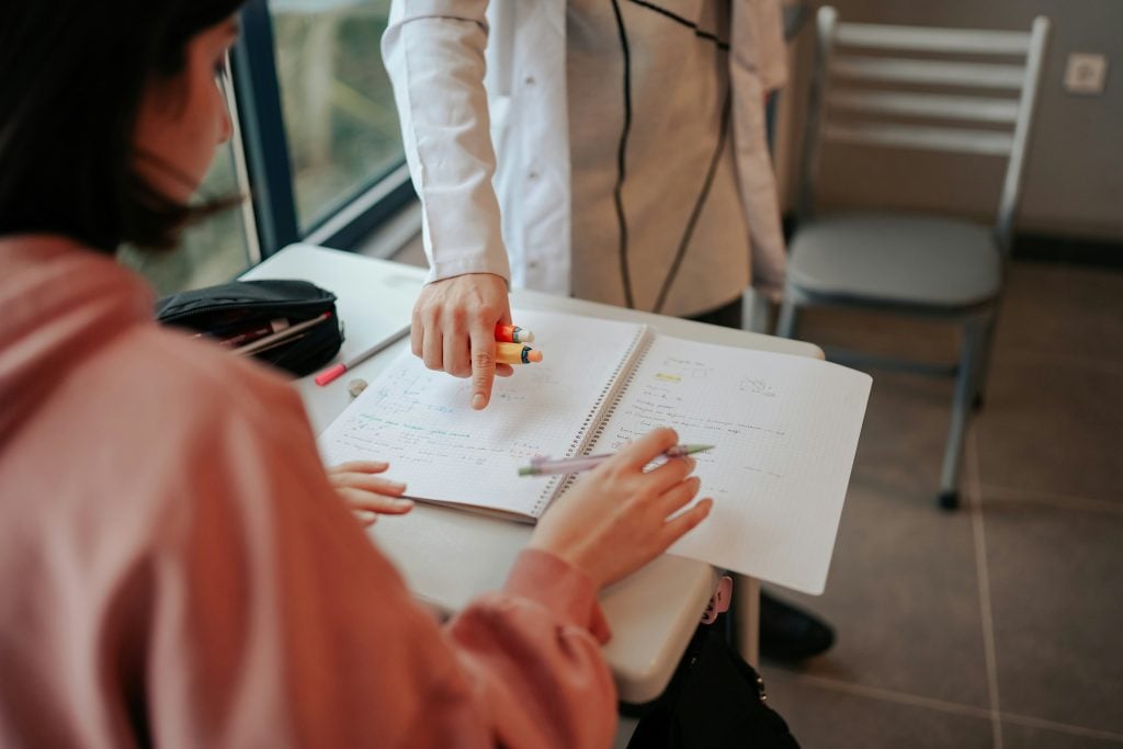 Antes de começarmos, você sabe o que são as avaliações ativas? É uma estratégia de avaliação que envolve os estudantes de forma mais participativa e dinâmica em seu próprio aprendizado. As avaliações ativas buscam promover o engajamento dos estudantes, permitindo que eles reflitam sobre suas aprendizagens, deem e recebam feedbacks, e tenham a oportunidade de melhorar de maneira contínua, fazendo parte de todo o processo. As avaliações ativas estão se destacando como uma nova abordagem no ensino, em contraste com a prova individual e sem consulta, que ainda é o principal modelo de avaliação no ensino tradicional. Este formato, muitas vezes acompanhado por aulas expositivas, é facilmente reconhecido por pais e educadores. Essa familiaridade vem das experiências que tiveram enquanto estudantes, o que leva à repetição desses métodos sem questionamentos ou análise. Além disso, as provas individuais, especialmente as de múltipla escolha, são práticas, objetivas e fáceis de corrigir, criando uma sensação de controle e previsibilidade para escolas e famílias. No entanto, ao adotar avaliações ativas, é possível transformar essa dinâmica, promovendo um aprendizado mais engajador e profundo, que vai além da simples memorização e repetição. Desafios para adotar avaliações ativas No entanto, nos cursos de formação de professores, não se fala muito sobre outros tipos de avaliação, então rola uma insegurança na hora de adotar um novo método. E muita gente ainda acha que qualquer forma diferente de avaliar vai virar “nota alta garantida”, especialmente se não tiver o rigor das provas. Mas essas avaliações tradicionais focam muito na memorização e deixam de lado algumas habilidades mais complexas, como o trabalho em grupo e as competências socioemocionais. Além disso, a pressão para ser o melhor da turma só aumenta a ansiedade e acaba prejudicando o aprendizado, o que reforça a necessidade de repensar essa prática como a melhor (e única) maneira de avaliar. Pequenas ações, grandes resultados Agora, calma! Não precisa jogar tudo fora. Existem pequenas ações que o professor pode fazer nas provas para melhorar a experiência dos estudantes, deixar o aprendizado mais dinâmico e fazer com que eles se comprometam mais. Sem contar que, com isso, o professor também consegue entender melhor como os estudantes estão se preparando, o que eles já dominam e onde estão as dificuldades. A ideia não é fornecer as respostas prontas, mas criar oportunidades para que eles possam se preparar de forma mais estratégica, promovendo uma compreensão real dos conteúdos e um engajamento maior. Conheça 3 ações de avaliações ativas que o professor pode adotar durante a prova: Permita consultar as anotações feitas pelo estudante Quando a gente pensa em “colar”, logo vem à mente alguém trapaceando e quebrando as regras, né? Mas permitir que os estudantes usem suas próprias anotações não é isso! Na verdade, pedir que eles façam essas anotações já é uma forma de estudo. Ao preparar suas anotações, o estudante precisa desenvolver habilidades de síntese e selecionar os tópicos que serão anotados, ou seja, estão revisando o conteúdo sem nem perceber. Uma dica é limitar essas anotações a meia folha ou uma folha A4, que tem que obrigatoriamente ser manuscrita e feita por eles. Ao final da avaliação, o professor pode recolher as folhas e entender o que os alunos acharam mais relevante. Além disso, essa "colinha oficial" reduz bastante a ansiedade e faz com que pequenos problemas de memorização não influenciem tanto em seus resultados. Permita perguntas durante a prova Depois que pelo menos 60% do tempo da prova já tiver passado, faça um sorteio e forme duplas. Um aluno faz uma pergunta em voz alta, e o outro só pode responder com “Sim”, “Não” ou “Não sei”. Mas, atenção! Já combine com os estudantes que as perguntas têm que ser sobre o conteúdo da prova, nada de pedir cola direta sobre as questões, hein?! Permita um momento de discussão geral Se a prova tiver perguntas mais discursivas e exigir respostas mais elaboradas, deixe a galera conversar entre si por uns dois minutinhos. Sim, eles podem falar sobre a prova e suas questões, mas sem anotar nada, apenas dialogar. Essa ação fortalecerá a capacidade de síntese, ajudando-os a elaborar perguntas que atendam às suas necessidades e a dar respostas coesas, além de esclarecer pequenas dúvidas pontuais que, se não resolvidas, podem comprometer sua nota final. Avaliações ativas como ferramenta de aprendizado Essas ações que conversamos até agora, não tem como o objetivo de forma artificial, elevar as notas dos estudantes, mas sim garantir que os resultados da avaliação não se limitem à memorização pura e simples. É sobre dar aos alunos a chance de serem protagonistas do próprio aprendizado. Mas claro, cabe ao professor tomar cuidados especiais para que o processo continue sendo justo. Por exemplo, se vai permitir a consulta das anotações, as questões da prova não podem ser cópias exatas de exercícios já feitos em sala. A ideia é estimular a aplicação do conteúdo e o pensamento crítico. No fim, repensar as formas de avaliar significa abrir espaço para práticas que incentivam mais autonomia e uma compreensão mais profunda do que foi aprendido. No fim das contas, repensar as formas de avaliar significa abrir espaço para práticas que incentivam mais autonomia e uma compreensão mais profunda do que foi aprendido. Com algumas mudanças simples, o processo avaliativo pode deixar de ser só um momento de teste e virar uma ferramenta poderosa de aprendizado. Vamos deixar de lado o "sempre foi assim" e explorar o "por que não tentar diferente?"! 